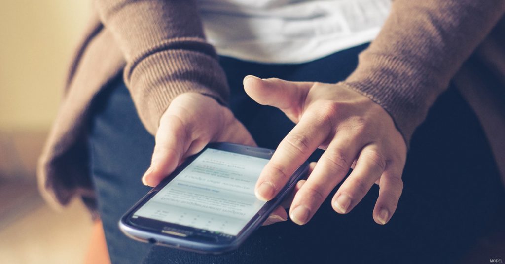 A woman researches the benefits of a rhinoplasty on her phone.