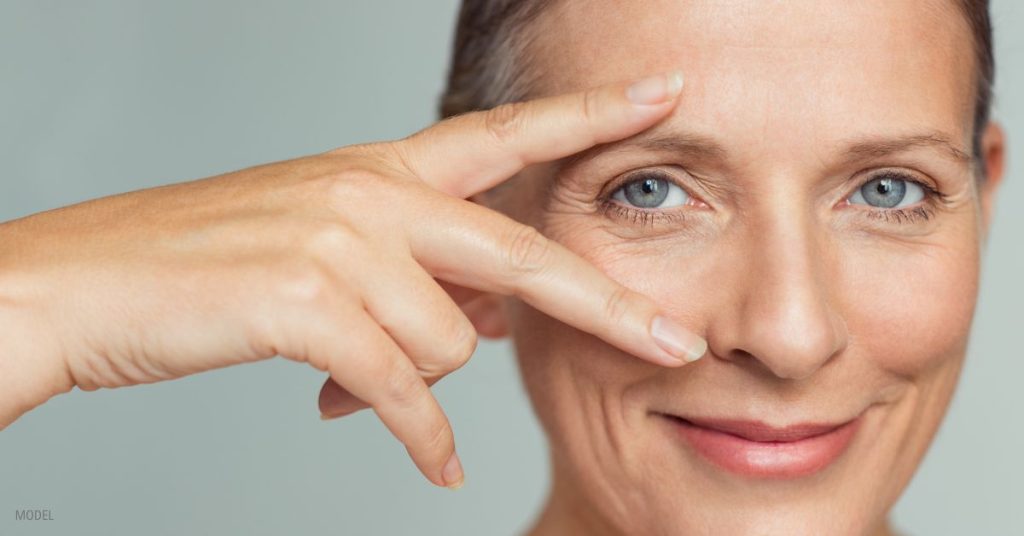 Mature women smiling with hands on her face (MODEL)